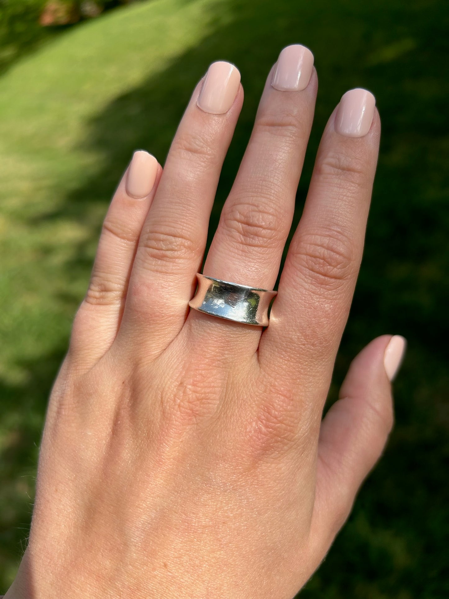 Close-up of a Canyon Jewelry lariat ring resting on a textured moss-covered surface, with a blurred background enhancing the focus on the jewelry.