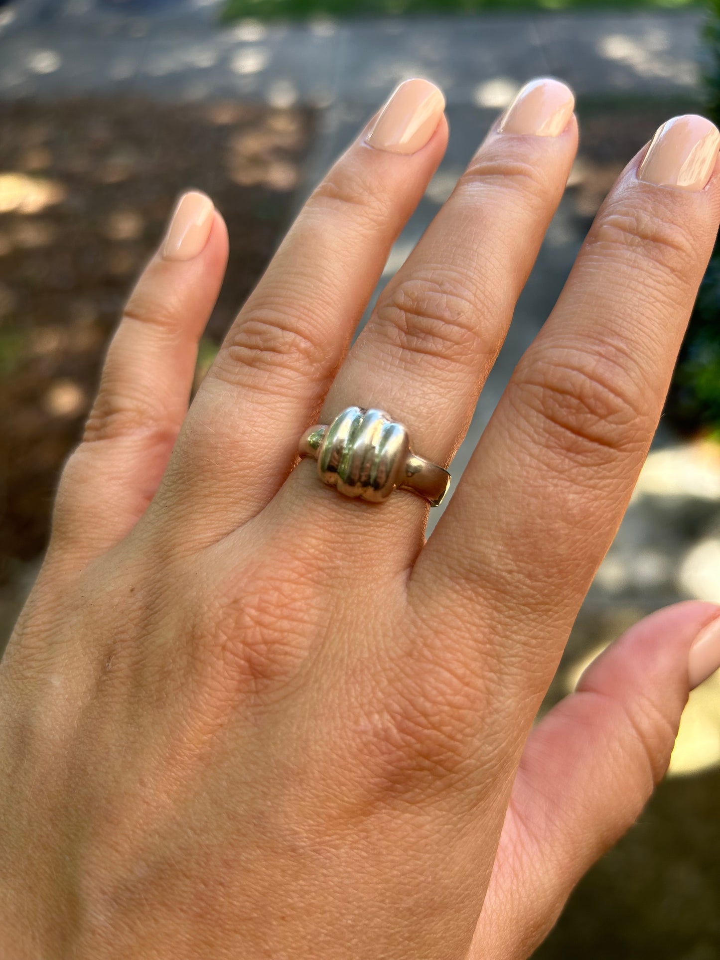 Close-up of a vintage sterling silver Homestead Ring by Canyon Jewelry with a unique textured design, resting on a moss-covered surface with a blurred background.
